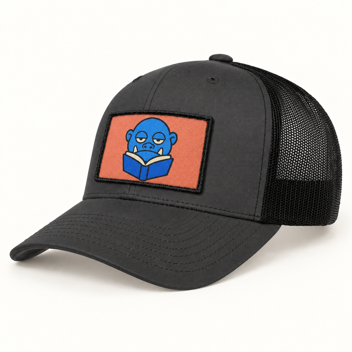 Koloss Learns to Read patch illustrated on a charcoal and black trucker hat. Hat sold separately.